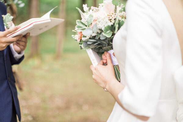 Bride and groom exchanging wedding vows wedding ceremony in nature.