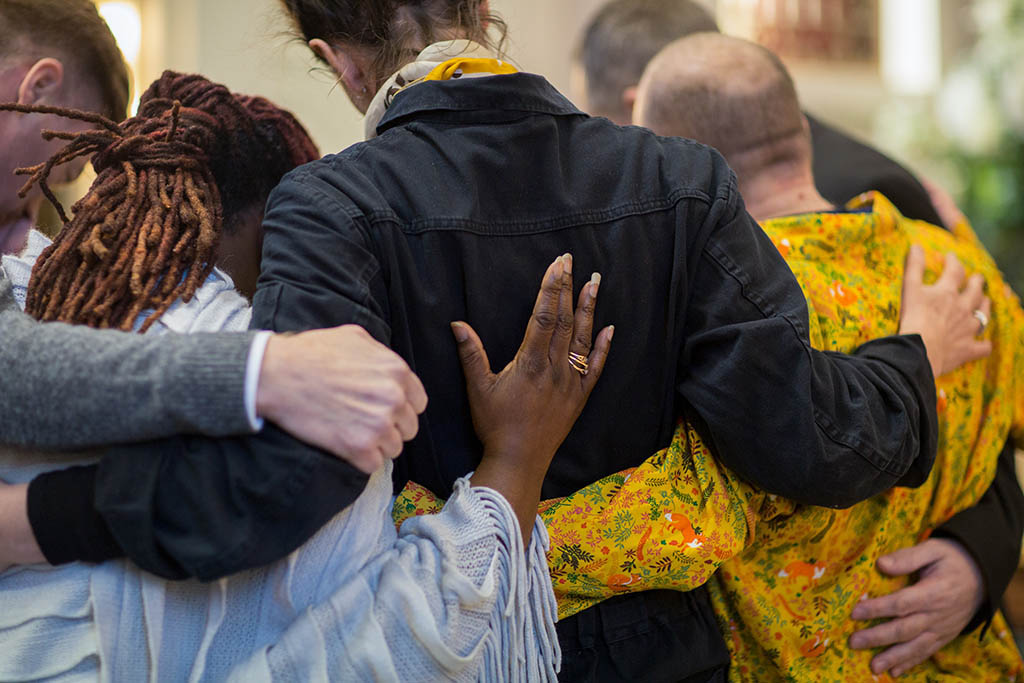 Family hugging and supporting each other at a funeral service